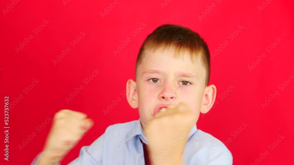 angry aggressive caucasian schoolboy 8-9 years old in uniform keeps his hands in fists,preparing for a fight looks at the camera.studio shooting red background.aggression schoolchildren concept angry aggressive caucasian schoolboy 8-9 years old in uniform keeps his hands in fists,preparing for a fight looks at the camera.studio shooting red background.aggression schoolchildren concept