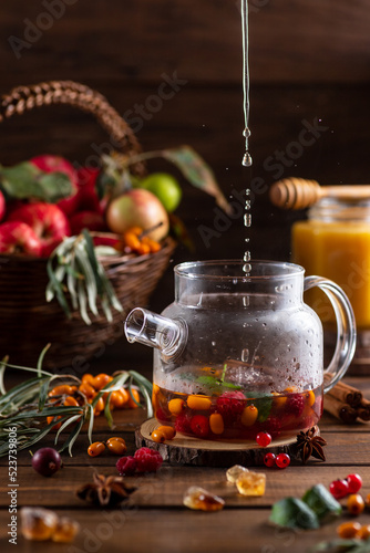 Boiling water is poured into a kettle with berries and spices