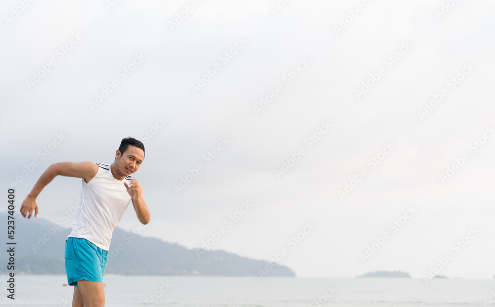 asian sport man running along seaside. running on beach with healthy toned legs body, Hamstring muscles, knee joint health active lifestyle panoramic banner background. the beach runners working out