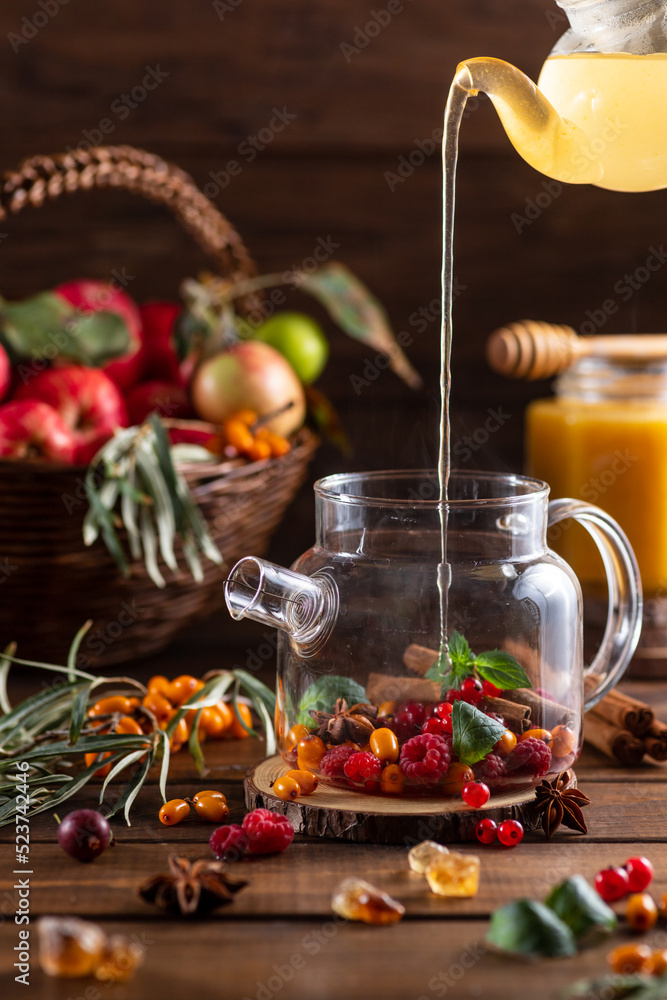 Fototapeta premium Boiling water is poured into a kettle with berries and spices