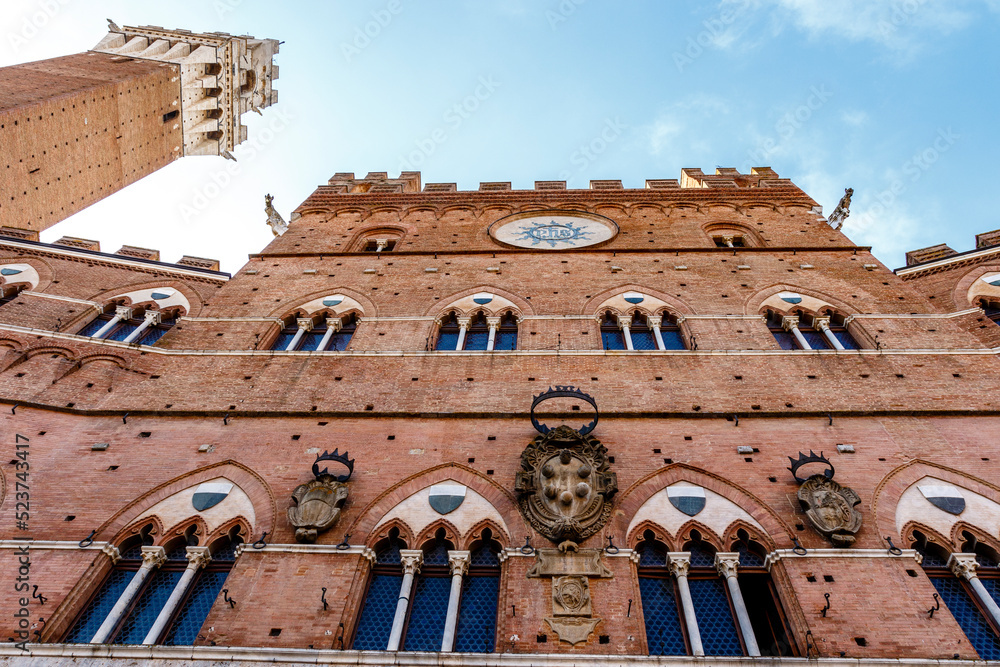 Fototapeta premium Exterior of the city hall and clock tower (in italian: Palazzo Comunale or Palazzo Pubblico) in Siena, Tuscany, Italy, Europe