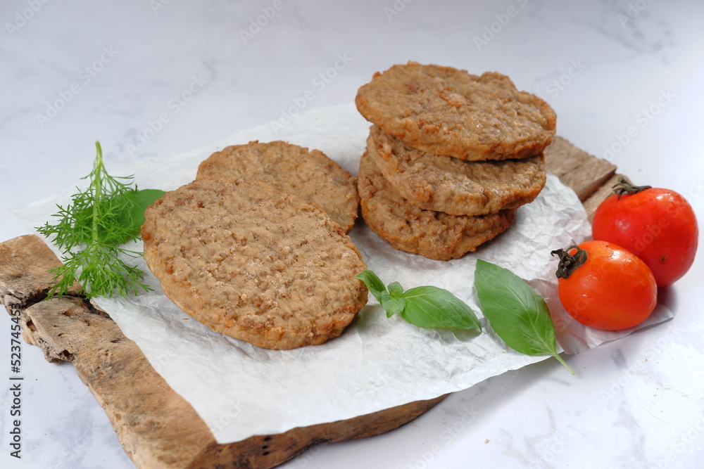 Burger meat patties with vegetables on white background. 