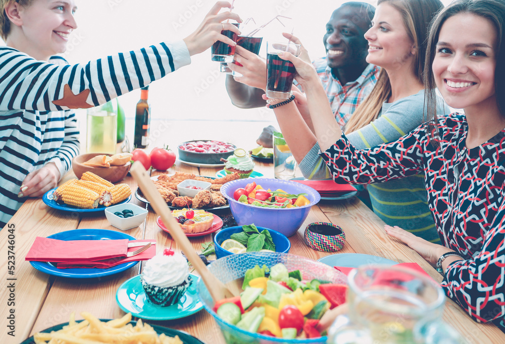 Top view of group of people having dinner together while sitting at wooden table. Food on the table. People eat fast food. Top view of group of people having dinner together while sitting at wooden table. Food on the table. People eat fast food.