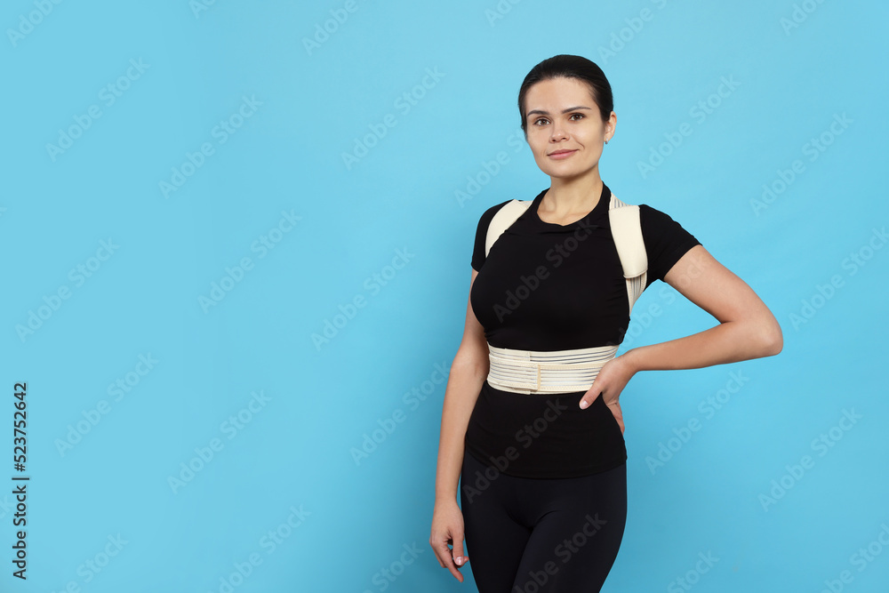 Beautiful woman with orthopedic corset on blue background, space for text Beautiful woman with orthopedic corset on blue background, space for text