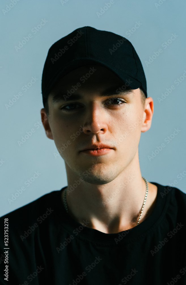 Portrait of stylish handsome caucasian man fashion model in t shirt and cap, studio shot. Portrait of stylish handsome caucasian man fashion model in t shirt and cap, studio shot.