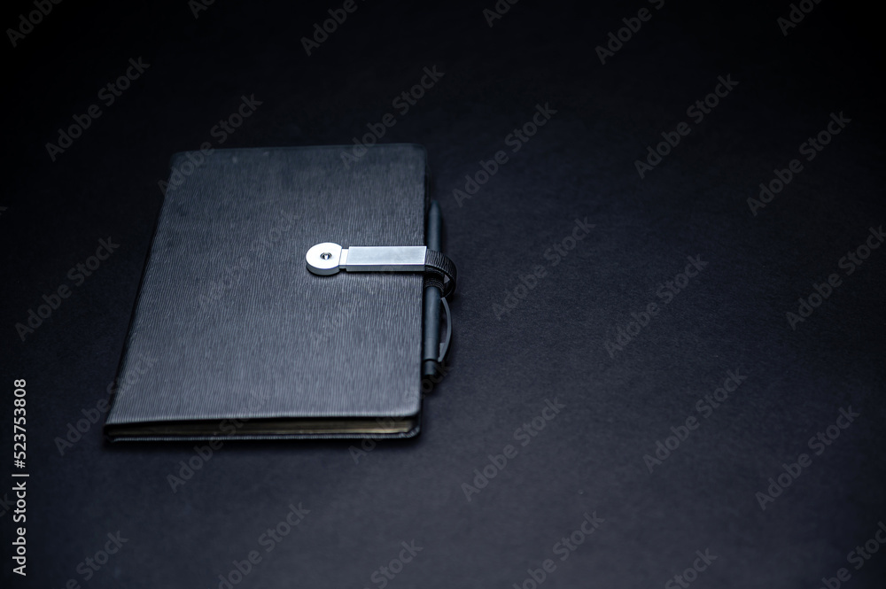 black planner or notebook with pen isolated on black background, mockup, copy space black planner or notebook with pen isolated on black background, mockup, copy space