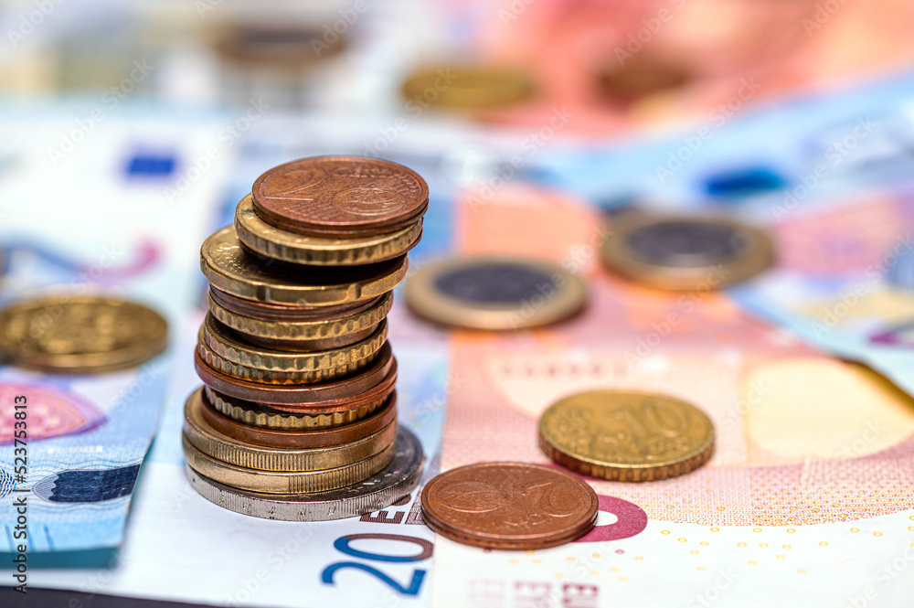 Tower with euro coins and banknotes in the background, close up
