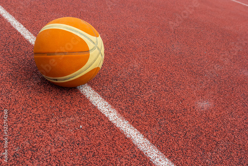 Orange ball for basketball lying on the sport court.Sport red court outdoor .Copy space.Top view