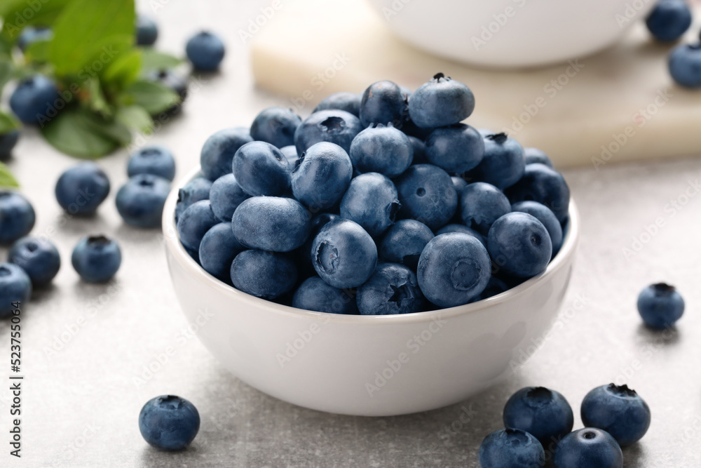 Tasty fresh blueberries on light grey table, closeup Tasty fresh blueberries on light grey table, closeup