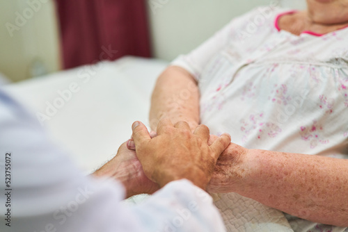 Nurses holding hands for comfort in the hospice photo