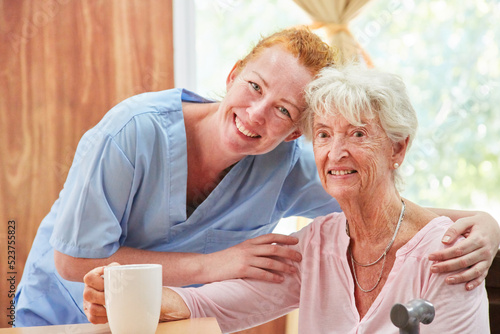 Smiling and caring caregiver and old woman