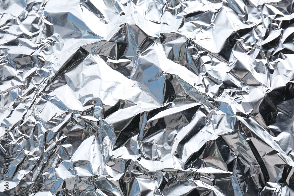 Crumpled silver foil as background, closeup view Crumpled silver foil as background, closeup view