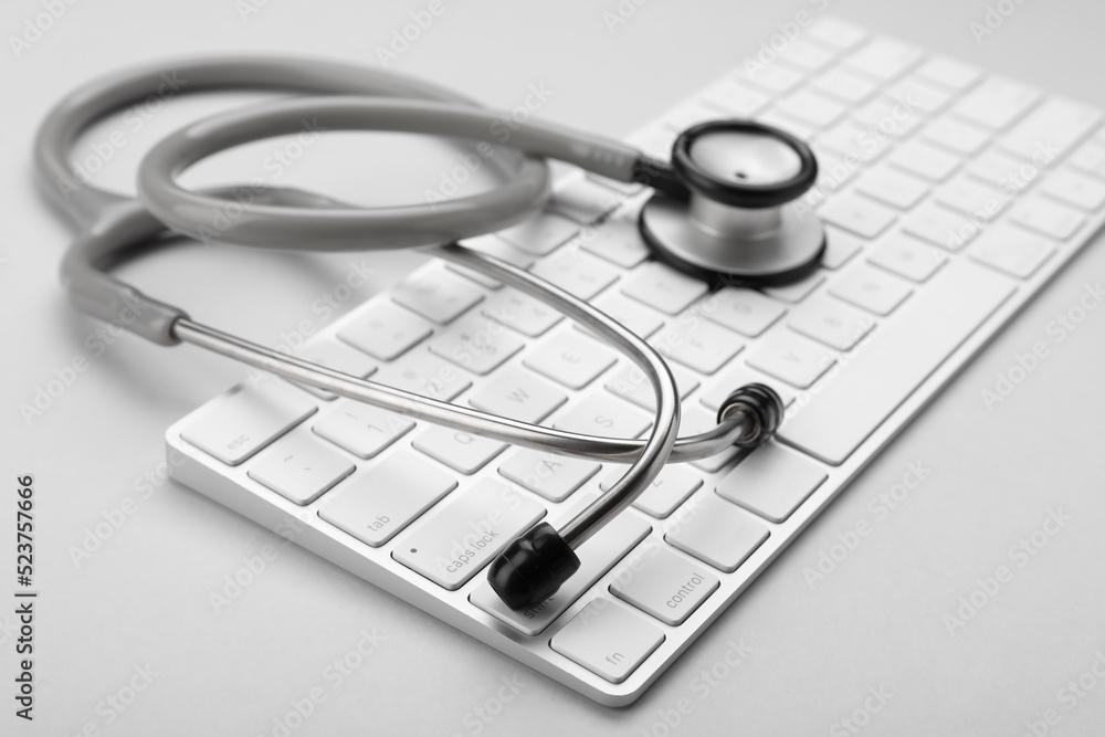 Keyboard and stethoscope on white background, closeup Keyboard and stethoscope on white background, closeup