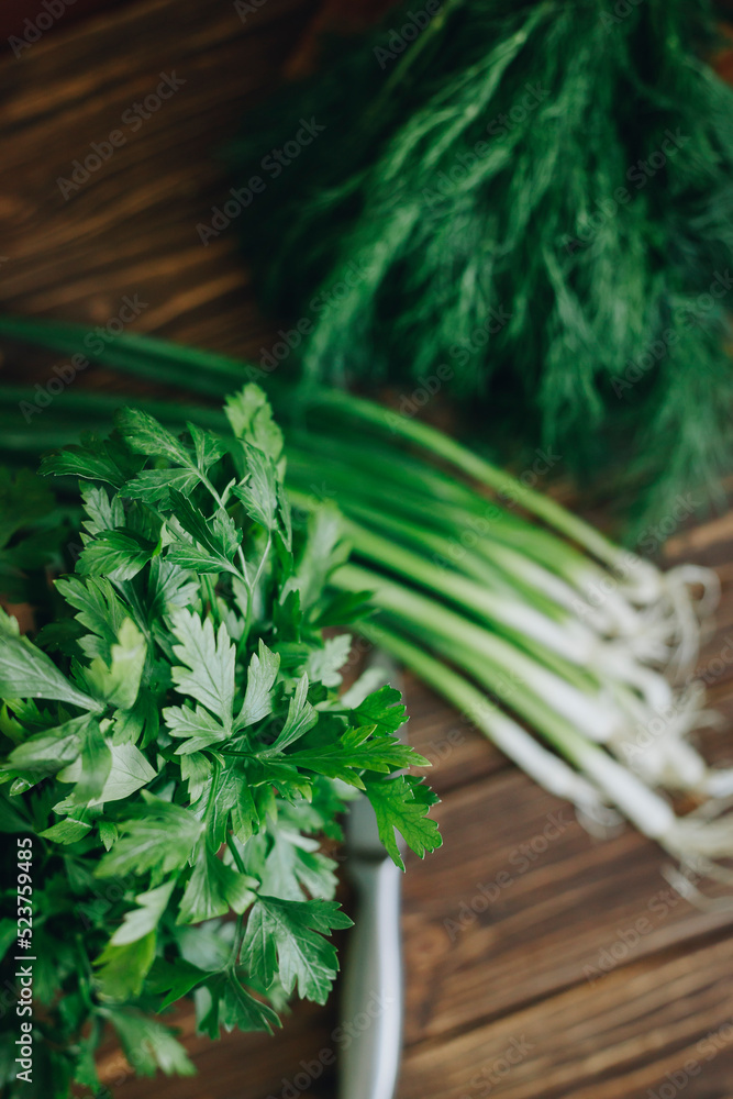 Fototapeta premium fresh green dill and parsley on wooden table
