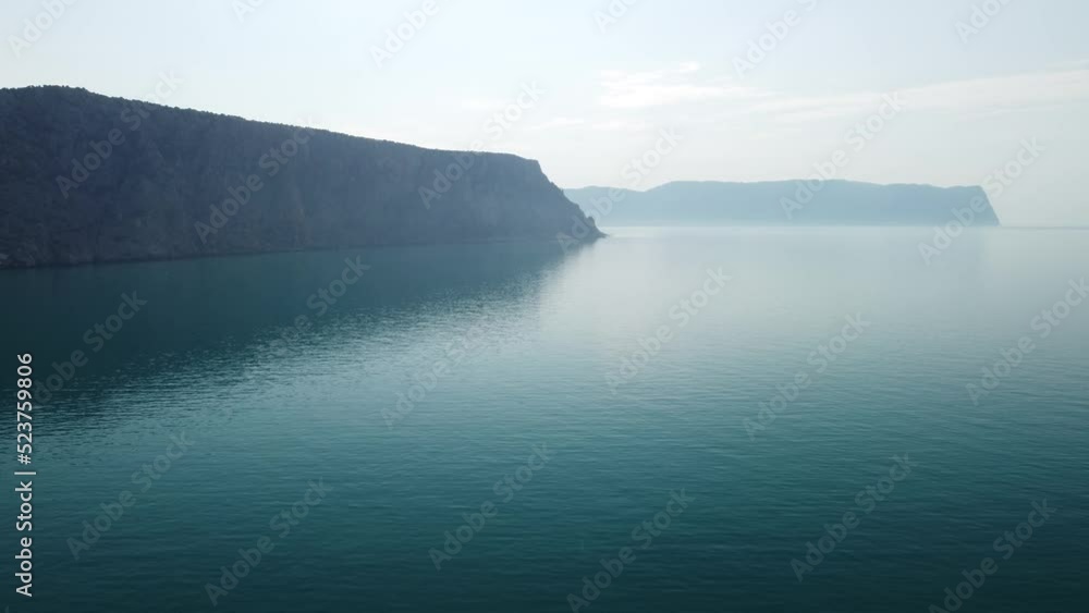 Aerial view from above on calm azure sea and volcanic rocky shores. Small waves on water surface in motion blur. Nature summer ocean sea beach background. Nobody. Holiday, vacation and travel concept Aerial view from above on calm azure sea and volcanic rocky shores. Small waves on water surface in motion blur. Nature summer ocean sea beach background. Nobody. Holiday, vacation and travel concept