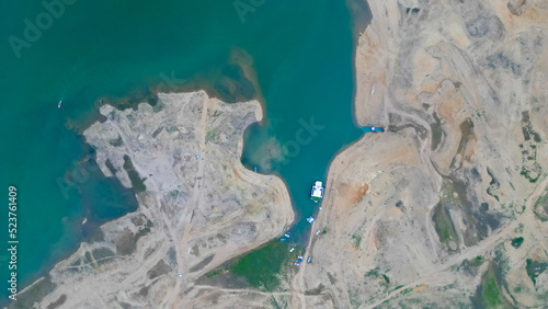 Aerial view Mangla Lake or river drone shot, Boat or ship standing at riverbank or lake shore with people swimming, pakistani or indian or south asian drone shot video  photo