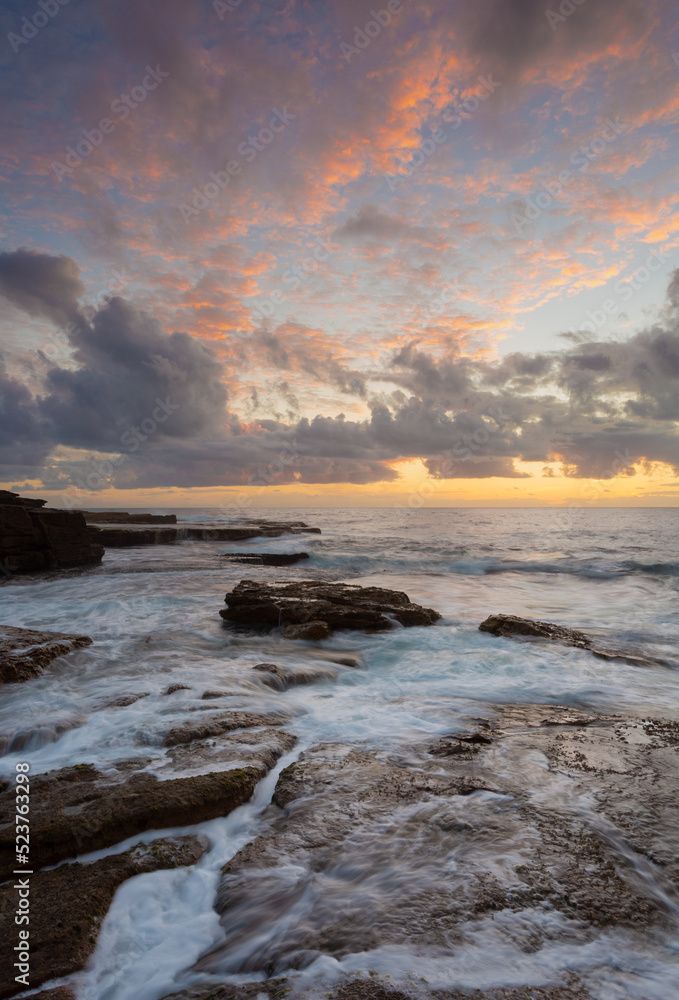 Sunrise over rocky ocean seascape