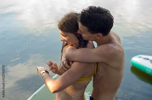 a couple in love on the river enjoys nature actively rests swims on a board uses a smart watch