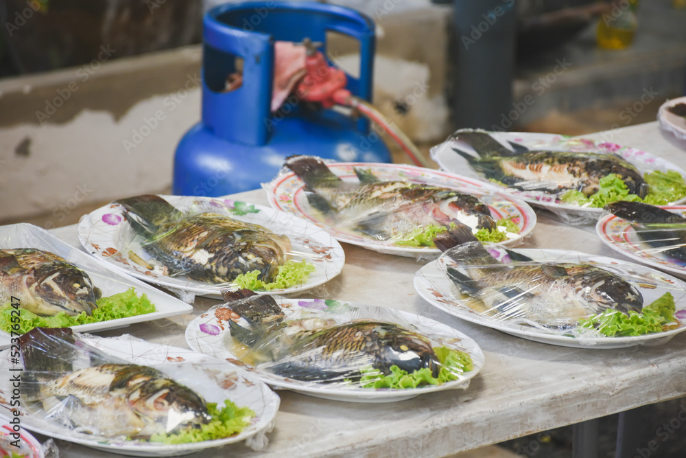 Grilled fish on the dining table in the building at noon Grilled fish on the dining table in the building at noon