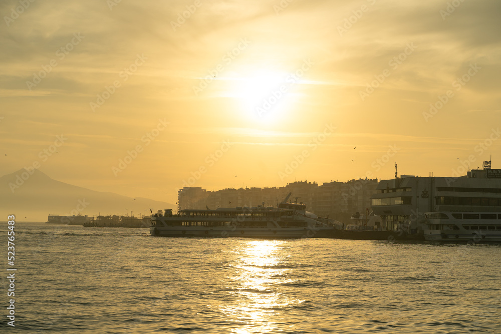 Ferry approaching the pier at sunset. Izmir, Karşıyaka pier in Aegean Sea.