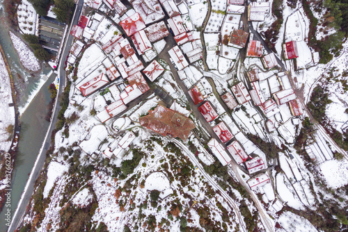 Snowy town in mountains on gloomy day in Spain photo