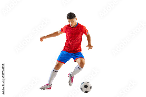 Portrait of young man, professional football player in motion, dribbling, training isolated over white studio background © Lustre