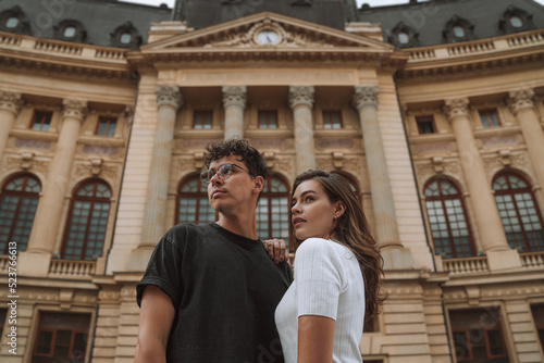 Enamored couple embracing and looking away during sightseeing trip photo