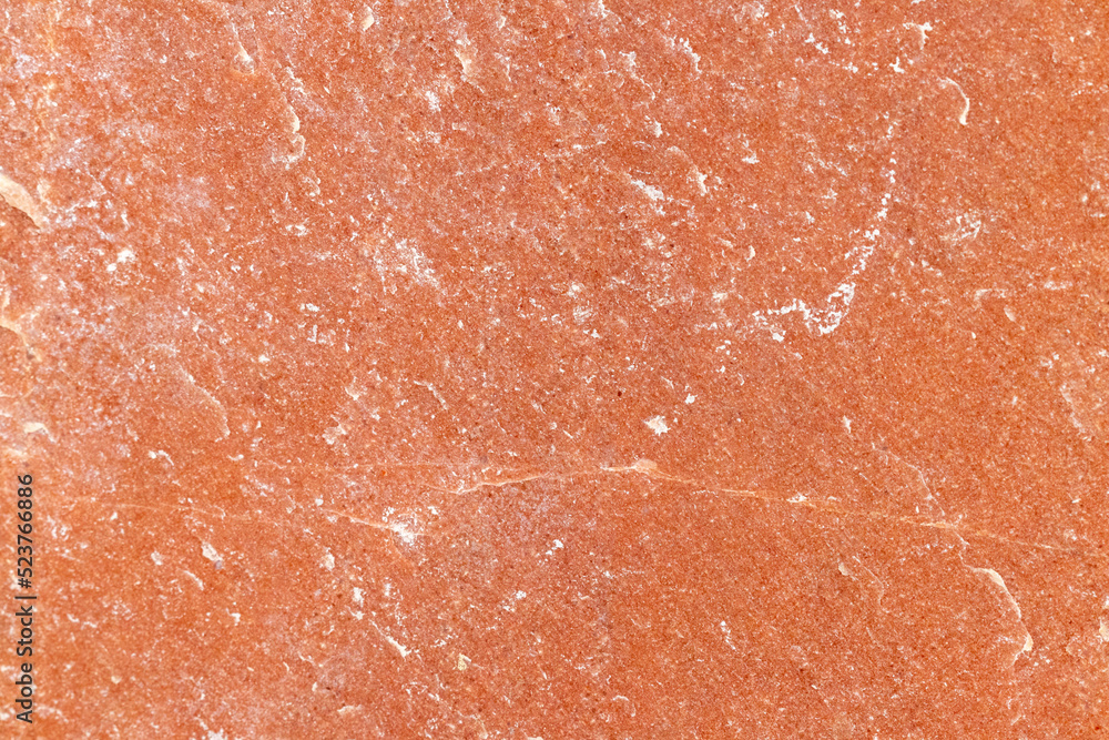 Texture of a stone wall with cracks and scratches which can be used as a backgr. Texture of red stone.