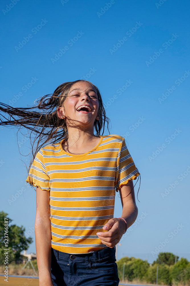 Happy girl with wet hair jumping on street Happy girl with wet hair jumping on street