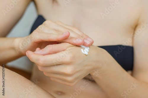 Moisturizer on female hands close-up. A woman applies moisturizer to her hands. Skin care