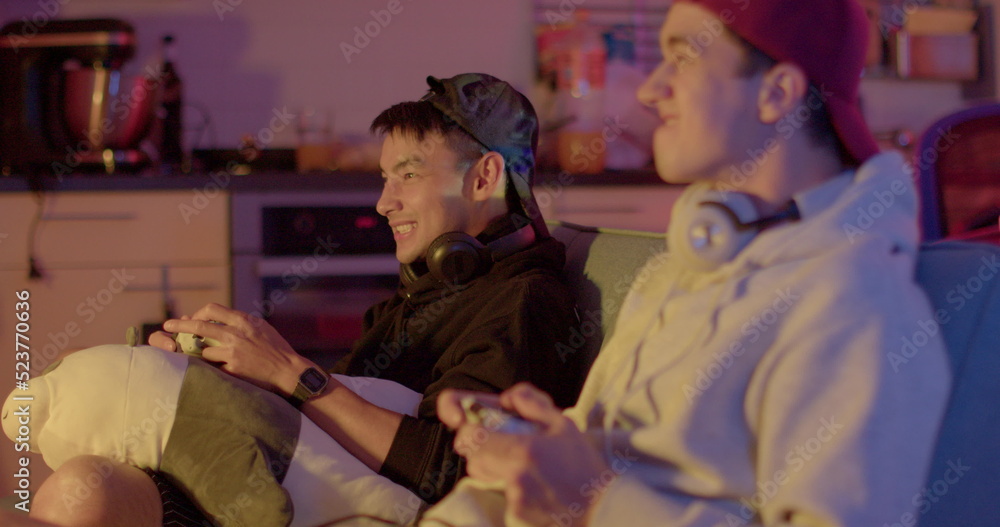 Expression of emotions on the face of video game players. Two guys use controllers in their hands. Move bodies, experience emotions. Evening room. Expression of emotions on the face of video game players. Two guys use controllers in their hands. Move bodies, experience emotions. Evening room.