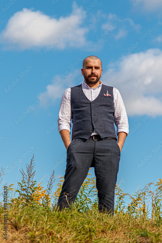 handsome guy in a suit among the field against the blue sky handsome guy in a suit among the field against the blue sky