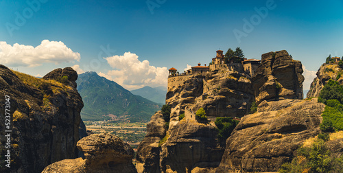 Traveling concept. Panoramic shot of the beautiful combination between nature and human. Impressive architecture of Meteora monasteries in Greece seen from afar. High quality photo