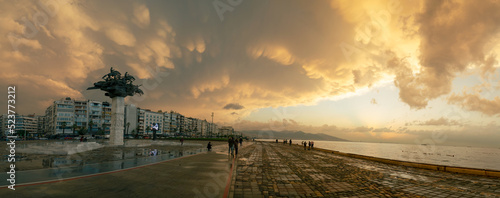 Izmir, Turkey - October 15, 2021: Panoramic view of the Gundogdu Square with Tree of Republic Statue, with mammatus cloudy sky
