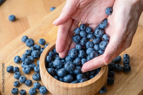 A woman sprinkles blueberries with her hands. Food healthy blueberry berry organic. tasty whortleberry photo