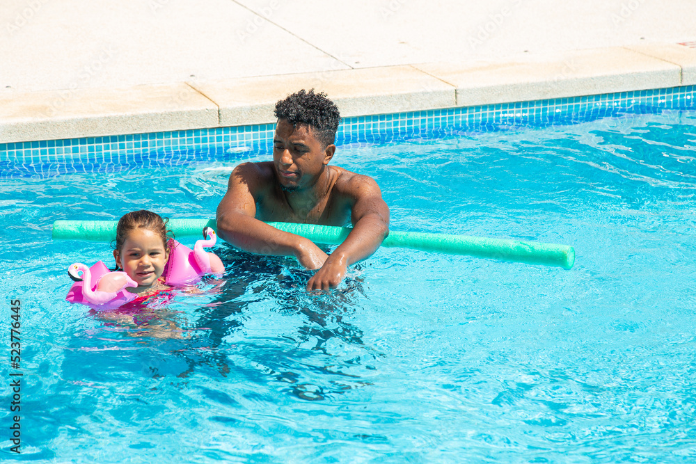 Father and daughter having fun in pool