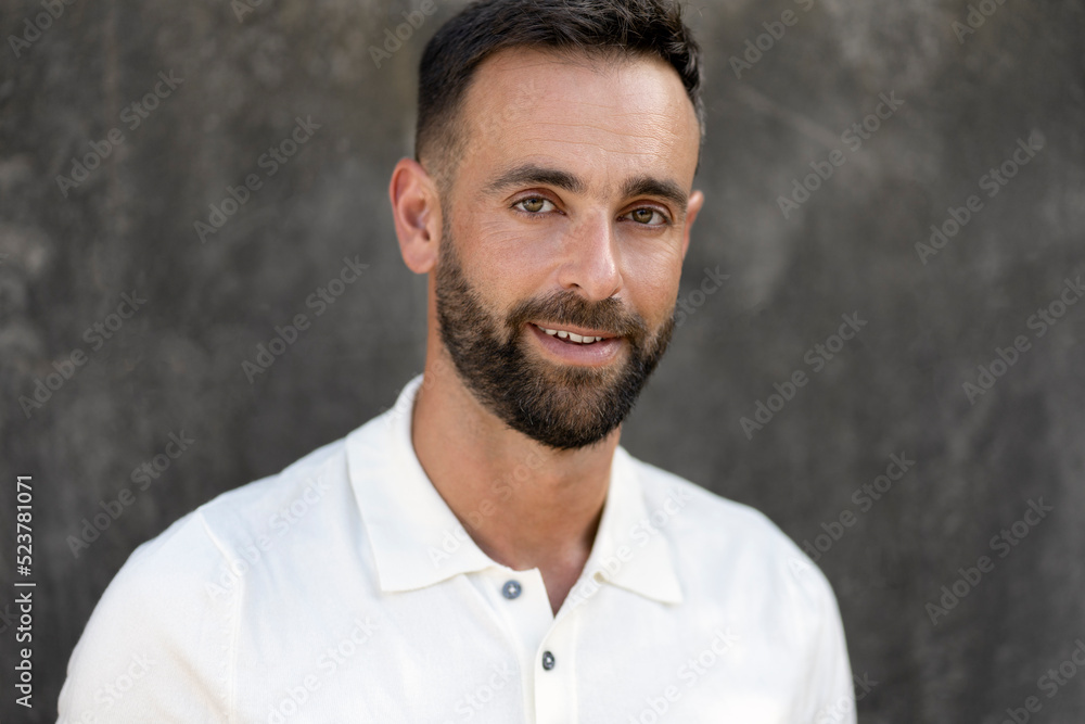Portrait of smiling handsome latin man with beard and stylish hair looking at camera isolated on grey background. Barbershop service concept Portrait of smiling handsome latin man with beard and stylish hair looking at camera isolated on grey background. Barbershop service concept