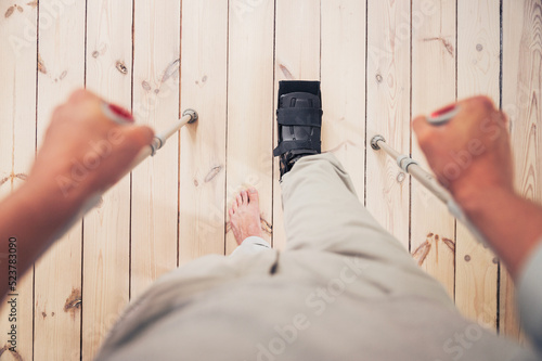 Man wearing ankle brace boot at home after injury...