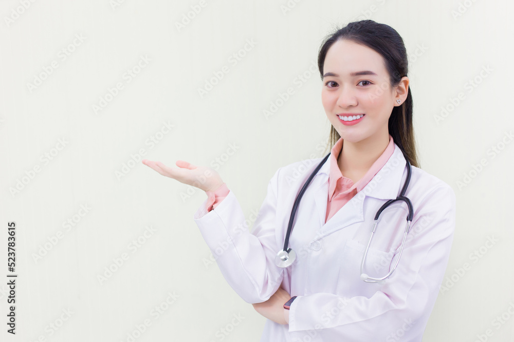 Professional Asian woman doctor shows her hand to present something while looking at the camera on white background. Professional Asian woman doctor shows her hand to present something while looking at the camera on white background.