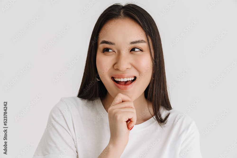 Asian young woman wearing t-shirt laughing and looking aside Asian young woman wearing t-shirt laughing and looking aside