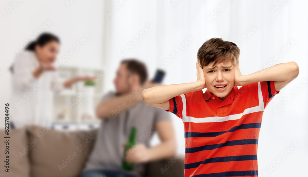 emotional abuse, family issue and violence concept - boy closing his ears with hands over parents fighting on background