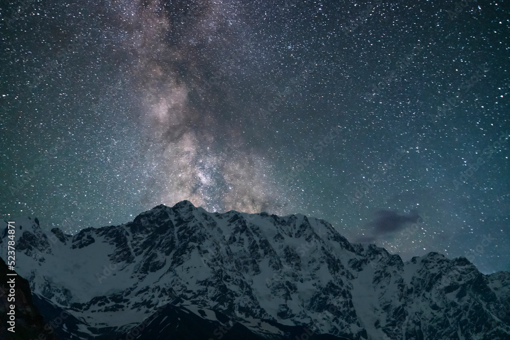 Beautiful snow covered mountain in the starry night with milky way galaxy.