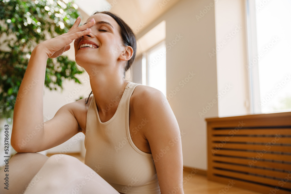 Young white woman laughing during yoga practice on mat Young white woman laughing during yoga practice on mat