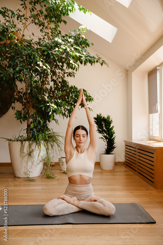 Young white woman doing exercise on mat during yoga practice