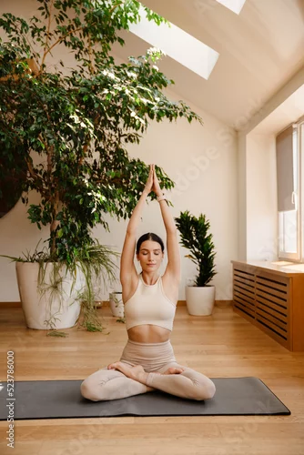 Obraz Young white woman doing exercise on mat during yoga practice