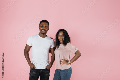 Young beautiful african american man and woman smiling and posing at camera isolated over pink background, copy space, banner.