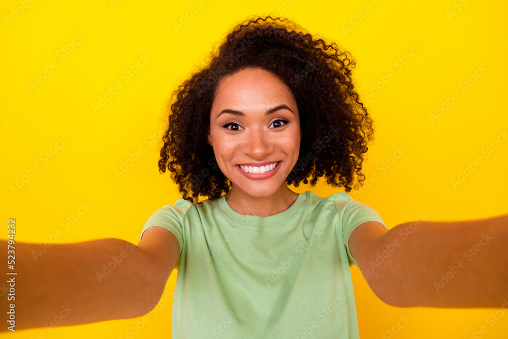 Photo of shiny cheerful lady wear green t-shirt recording self video smiling isolated yellow color background Photo of shiny cheerful lady wear green t-shirt recording self video smiling isolated yellow color background