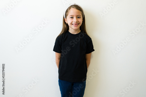 Cute girl smiling using a black mockup casual t-shirt