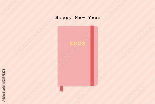 happy new yearの文字と2023年の刻印が入ったピンクの手帳の年賀状 
