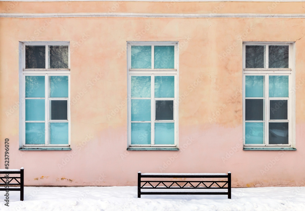 Three windows in pink wall on a winter day